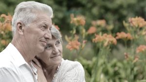 senior couple in the garden with flowers