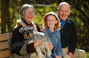 senior couple with granddaughter on a bench