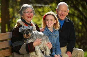 senior couple with granddaughter and dog
